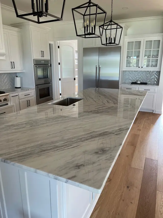 Large white and grey marble island with an undermount sink set into the stone