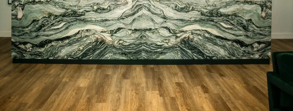 Front of a reception desk clad in bookmatched green and white stone